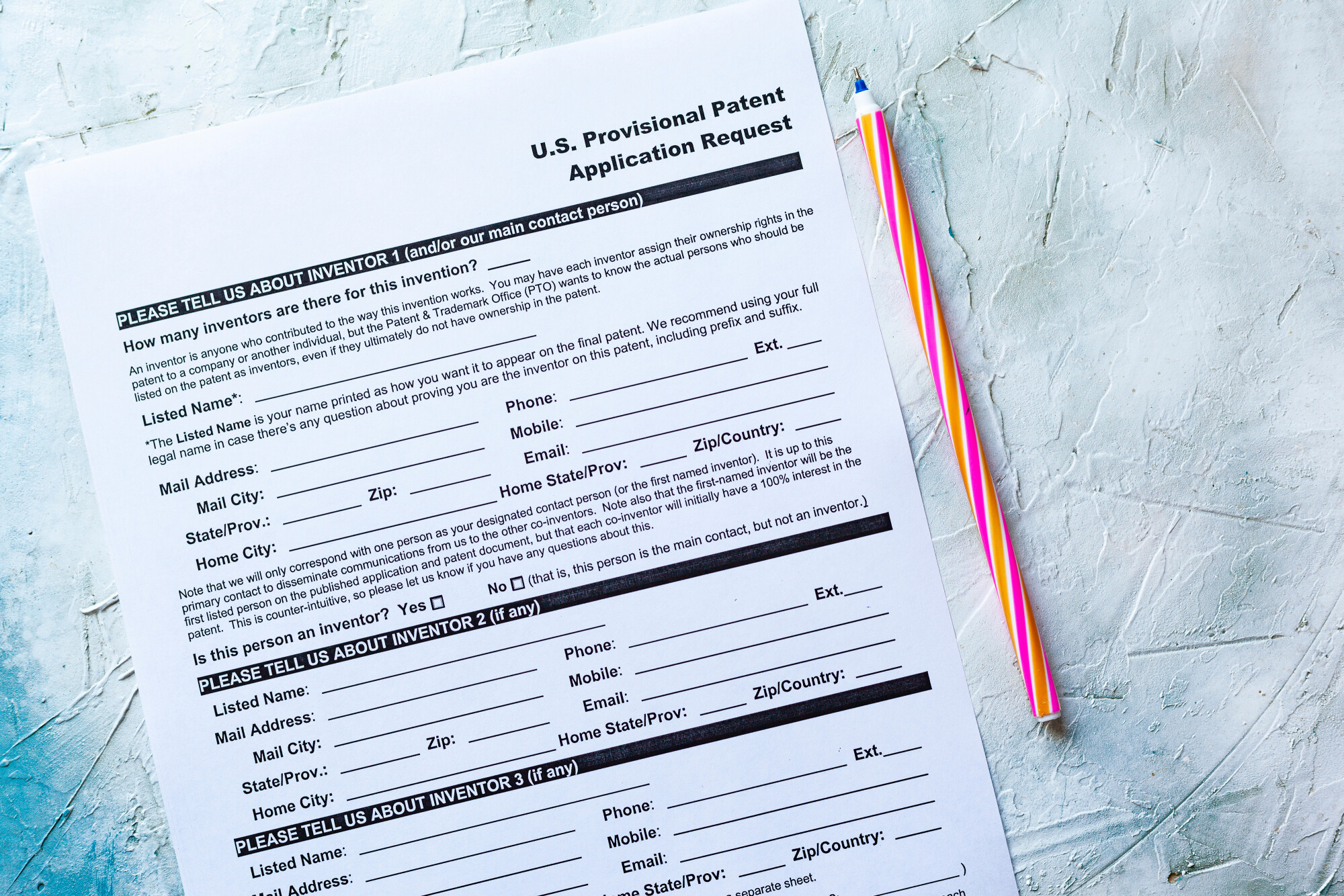 Provisional Patent Paper Application on White and Blue Background with red striped pen