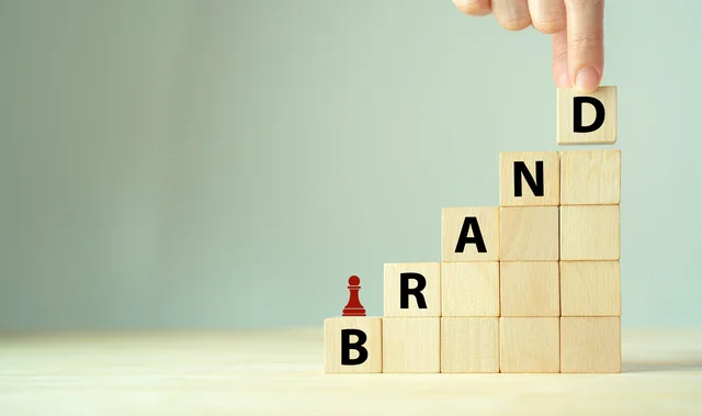 Wooden cube blocks with BRAND text and strategy icon on clean background.
