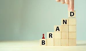 Wooden cube blocks with BRAND text and strategy icon on clean background.