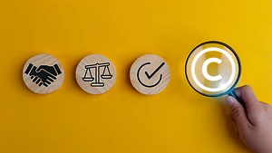 Magnifying glass magnifies copyright symbol. Copyright concept, author rights, and patented intellectual property. trademark license, and Creation ownership against piracy crime