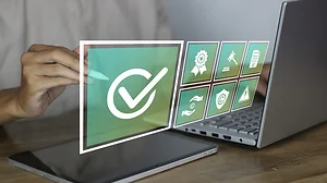 Business professional approving digital compliance checklist with certification, copyright, and security icons on virtual interface using laptop and tablet, representing legal standards
